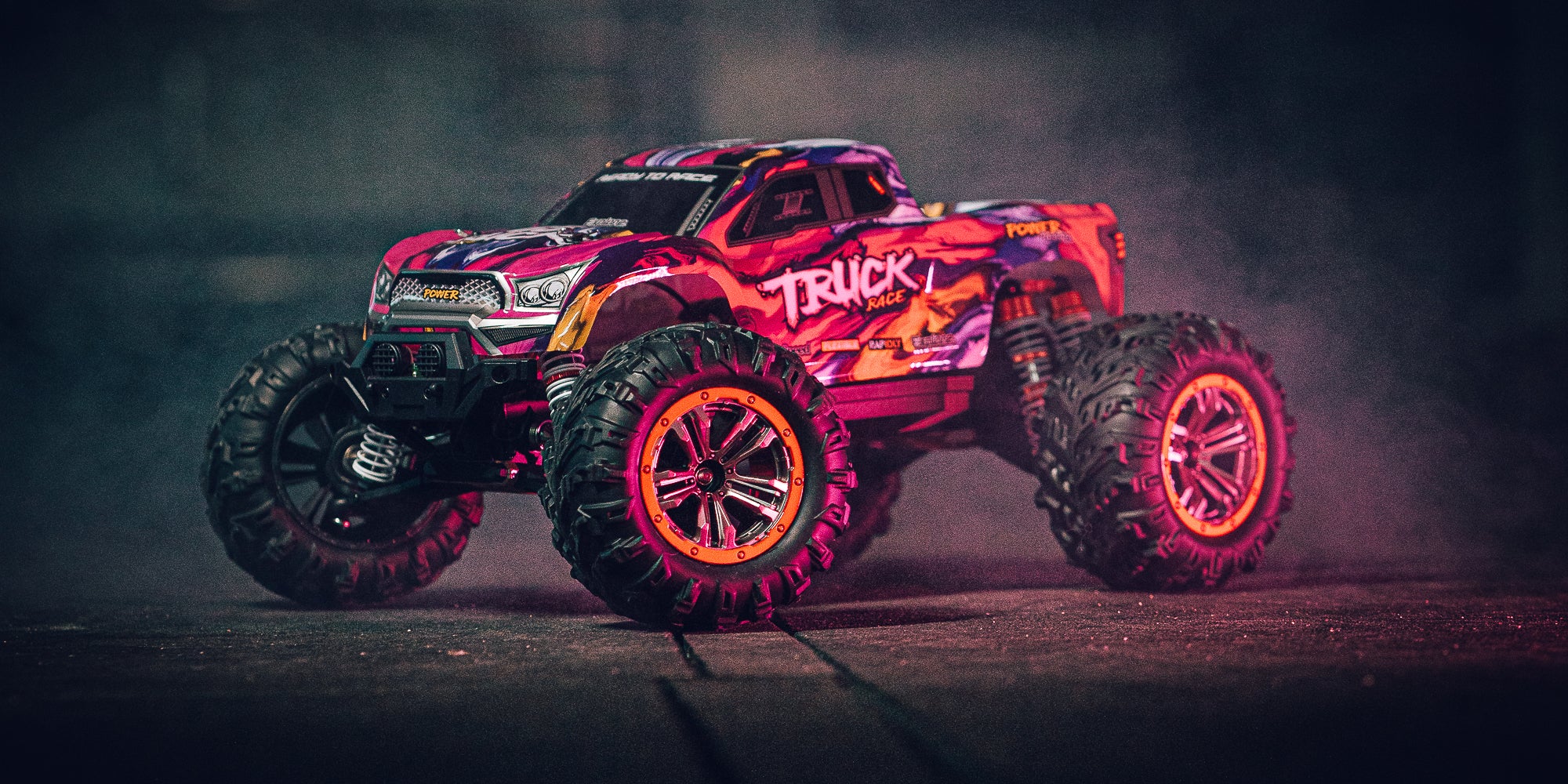 Orange XLH Race Truck fjernstyret monster truck kører gennem vandpyt med store sprøjt.
