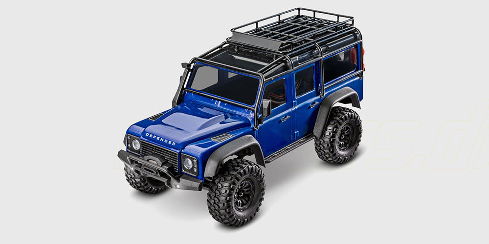 Mørkegrøn Traxxas TRX-4M Land Rover Defender crawler set skråt forfra på en hvid baggrund.