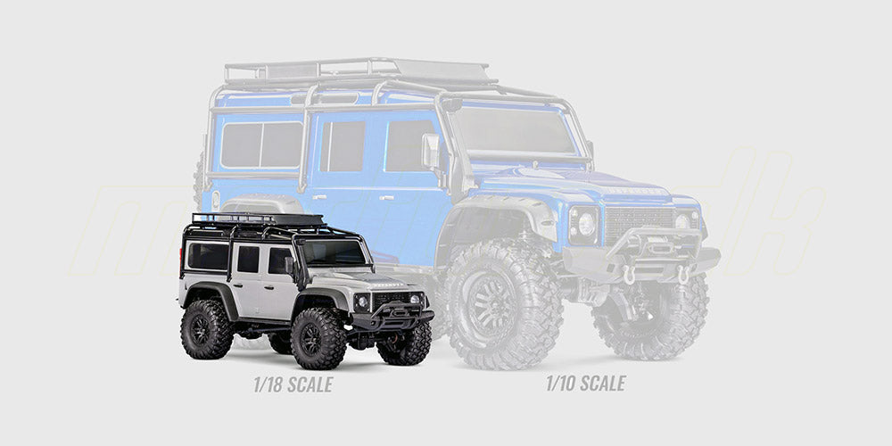 Grøn Traxxas TRX-4M Land Rover Defender crawler i størrelse 1:18 sammenlignet med en større fjernstyret bil.