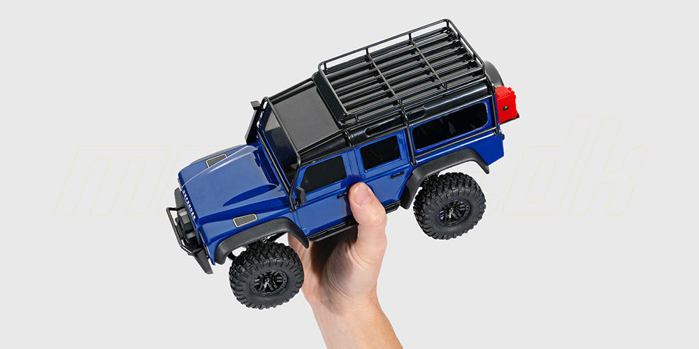 TRX-4M Defender fjernstyret bil i skala 1:18 holdt i en hånd for at vise den kompakte størrelse og detaljer.