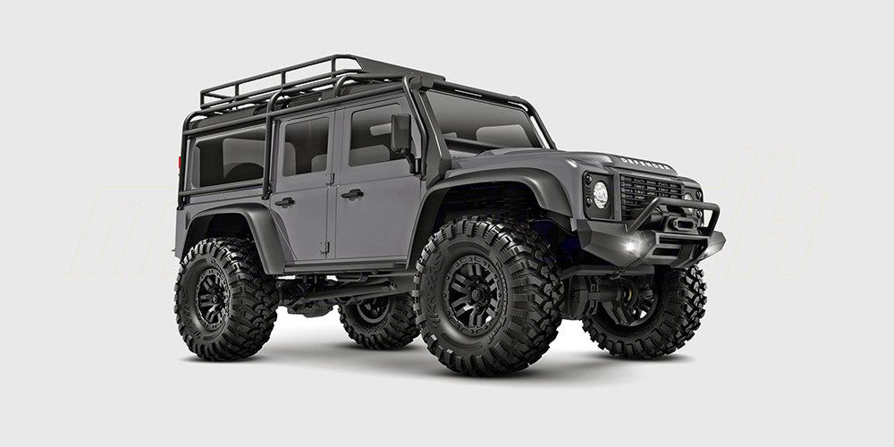 Sølvgrå Traxxas TRX-4M Land Rover Defender crawler i skala 1:18 set skråt forfra på hvid baggrund.