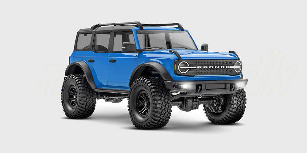 Blå Traxxas TRX-4M Ford Bronco fjernstyret crawler set skråt forfra på en hvid baggrund.