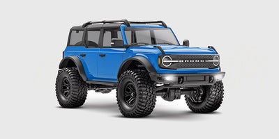 Blå Traxxas TRX-4M Ford Bronco fjernstyret crawler set skråt forfra på en hvid baggrund.