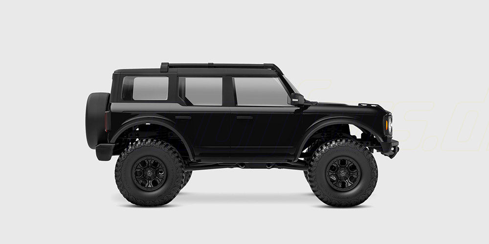 Sort Traxxas TRX-4M Ford Bronco fjernstyret bil set fra siden på hvid baggrund.