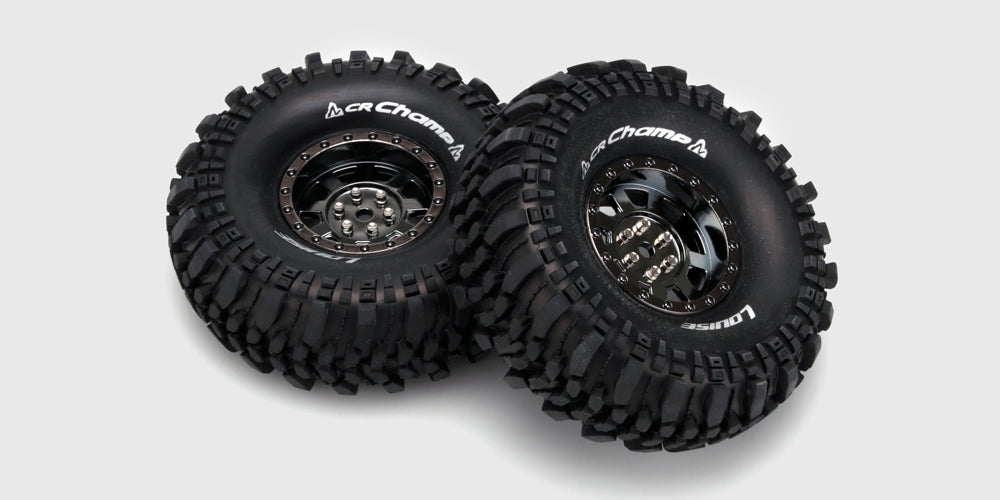 To sorte CR-Champ hjul med grove terrændæk og sølvfarvede fælge til fjernstyrede biler.