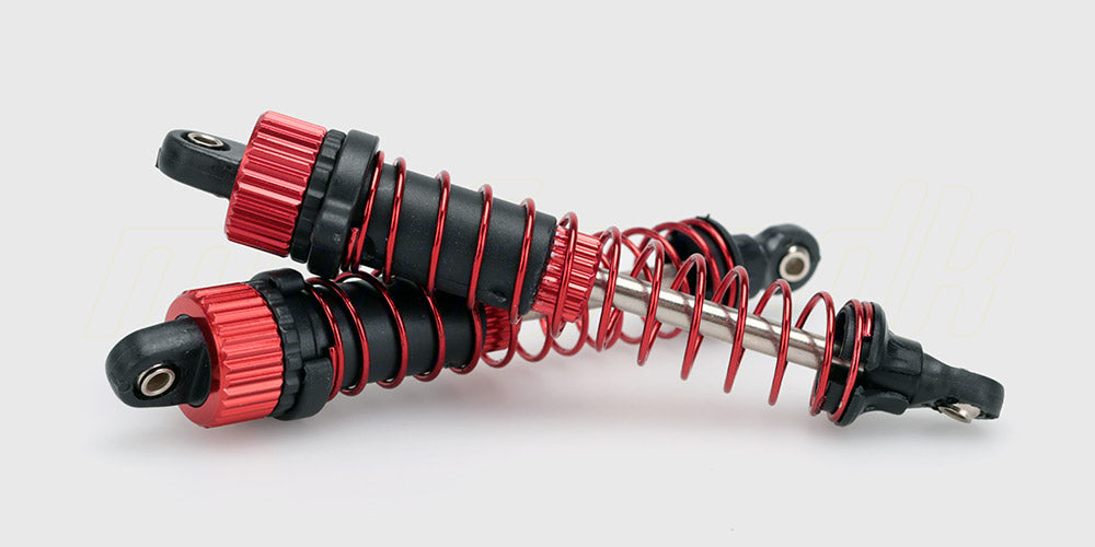 To sorte støddæmpere med sølvfarvede fjedre til Spirit XL fjernstyret bil vist på en hvid baggrund.