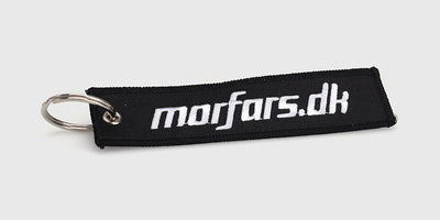 Sort Morfars.dk nøglering med hvidt logo monteret på et bundt nøgler.