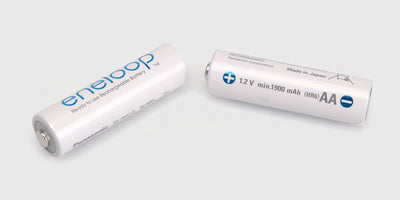 Hvid Panasonic Eneloop batterioplader med fire hvide genopladelige AA batterier på 1900mAh.