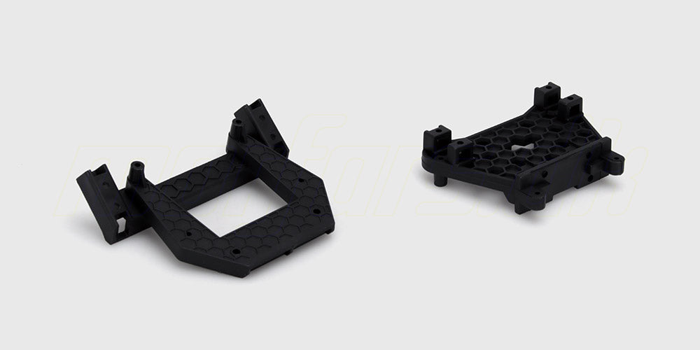 To sorte støddæmpertårne i plast til for- og bagende på en fjernstyret bil vist på en hvid baggrund.