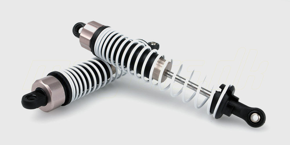 To sæt sorte frontstøddæmpere med metalfjedre til fjernstyret bil liggende på hvid baggrund.