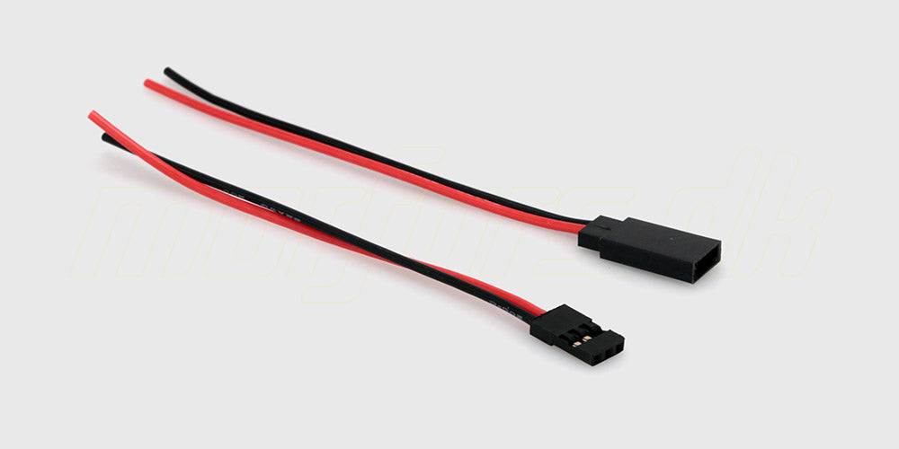 Futaba stiksæt med sorte og hvide plastikstik samt metalklemmer til fjernstyret udstyr på hvid baggrund.