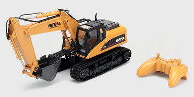 Gul fjernstyret gravemaskine med bevægelig skovl og larvefødder til realistisk leg på hvid baggrund.